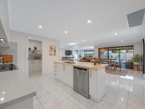 a kitchen with white appliances and a dining room at Central Haven in Yarrawonga