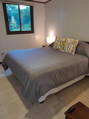1 dormitorio con 1 cama grande y ventana en Cabaña Familiar Puerto Varas, en Puerto Varas