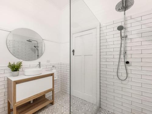 een witte badkamer met een wastafel en een douche bij Polly May's Rutherglen in Rutherglen