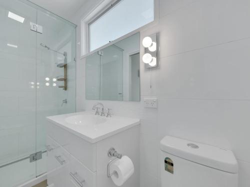 een witte badkamer met een wastafel en een spiegel bij Twin Rivers Whitehouse in Bundalong