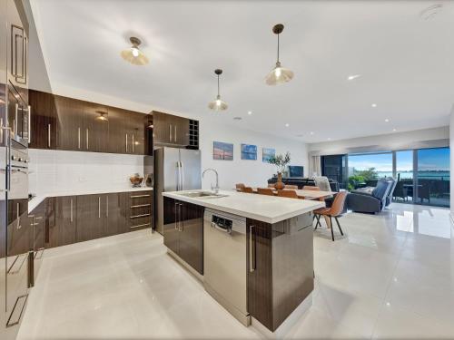 a kitchen with wooden cabinets and a table and a dining room at Kudoya Waters in Yarrawonga
