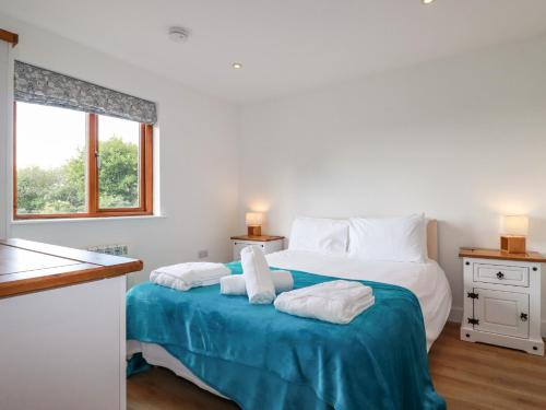 a bedroom with a large bed with towels on it at Tressa, Tor Down Quarry in Bodmin