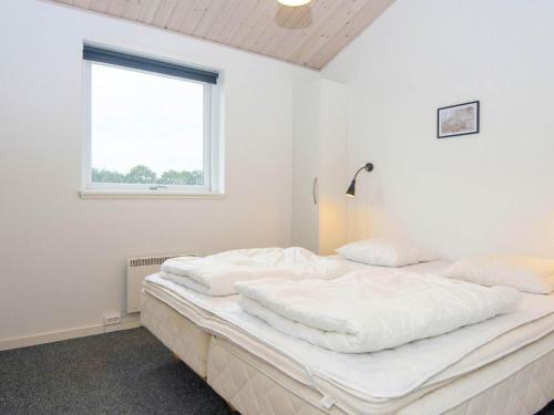 a white bedroom with a large bed with a window at 16 person holiday home in Ansager-By Traum in Ansager