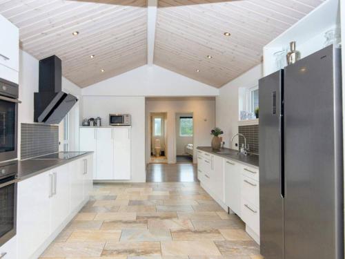 a kitchen with white cabinets and a wooden ceiling at 16 person holiday home in Ansager-By Traum in Ansager