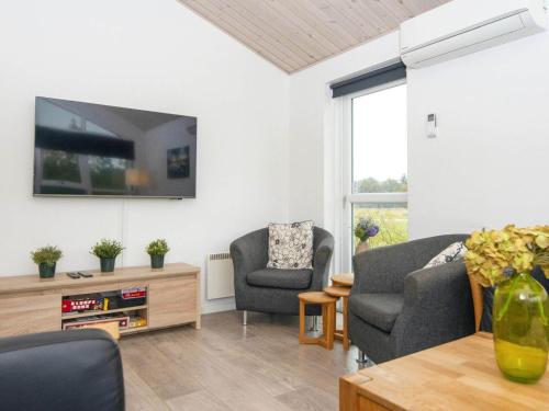 a living room with two chairs and a tv at 16 person holiday home in Ansager-By Traum in Ansager