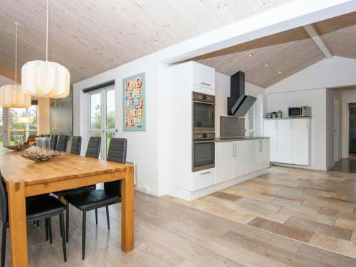 a kitchen and dining room with a wooden table and chairs at 16 person holiday home in Ansager-By Traum in Ansager