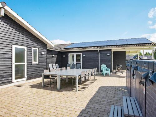 a patio with a table and chairs in front of a house at 16 person holiday home in Ansager-By Traum in Ansager