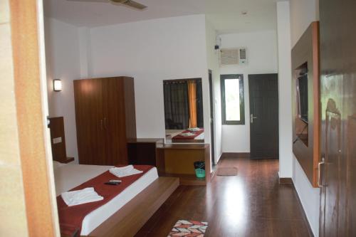 a room with a bed and a sink in it at Hotel Exotica Squares in Neil Island