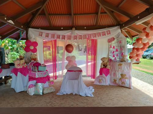 uma festa de aniversário rosa e branco com ursinhos de peluche e balões em Manantial de Vida em Bejuco