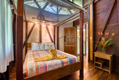 a bedroom with a bed with a pair of shoes on it at Tree House Beachfront Lodge in Puerto Viejo