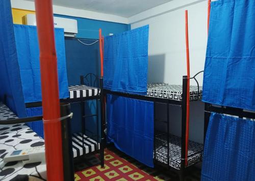 Habitación con paredes azules y literas negras. en Footprints Hostel, en Corón