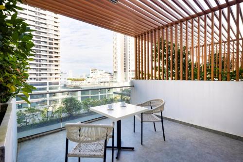a dining room with a table and chairs on a balcony at Anya Hotel Quy Nhon in Quy Nhon