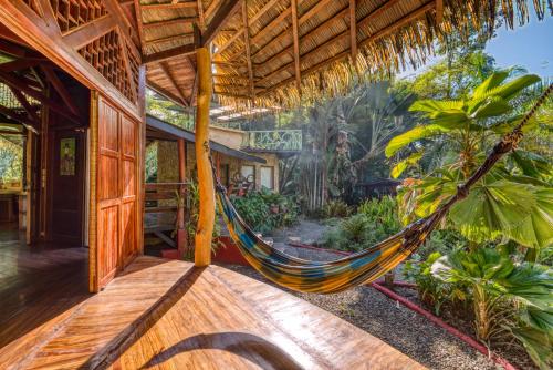 a hammock in a house with a garden at Tree House Beachfront Lodge in Puerto Viejo