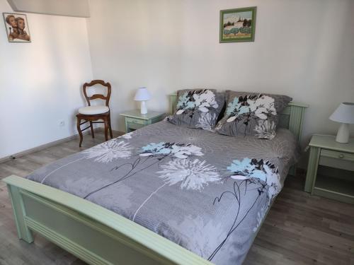 a bed with a purple comforter with flowers on it at Gîte Baldersheim, 4 pièces, 5 personnes - FR-1-744-6 in Baldersheim