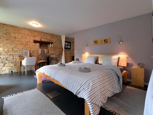 a bedroom with a large bed and a brick wall at Gîte Leymen, 2 pièces, 2 personnes - FR-1-744-7 in Leymen