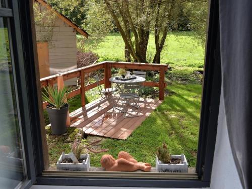a window view of a backyard with a table and a patio at Loft charmant à Leymen près de Bâle - Parking, espace vert, tout confort inclus - FR-1-744-7 in Leymen