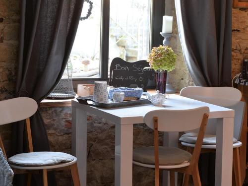 a table with chairs and a table with flowers on it at Loft charmant à Leymen près de Bâle - Parking, espace vert, tout confort inclus - FR-1-744-7 in Leymen