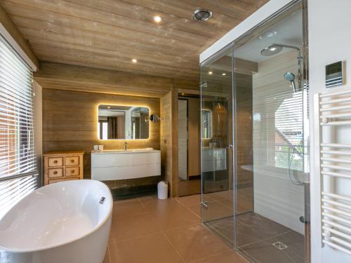 a bathroom with a tub and a sink and a shower at Appartement de prestige avec cheminée, balcon et wifi à Val-d'Isère - FR-1-694-320 in Val dʼIsère