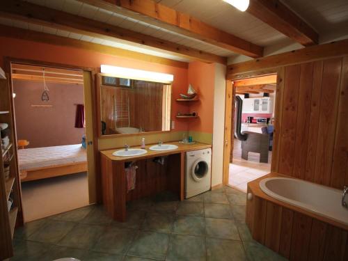 a bathroom with two sinks and a tub and a washing machine at Gîte Alsacien Authentique | 6 Pers. | Terrasses & Jardin | Adapté PMR - FR-1-744-18 in Bretten