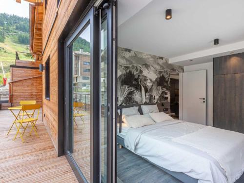 une chambre avec un grand lit et un balcon dans l'établissement Bel appartement avec wifi, garage, cheminée et grande terrasse au pied des pistes à Val-d'Isère - FR-1-694-325, à Val dʼIsère