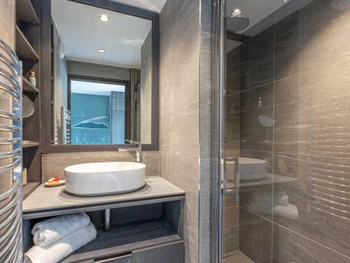 une salle de bain avec un lavabo et une douche en verre dans l'établissement Bel appartement avec wifi, garage, cheminée et grande terrasse au pied des pistes à Val-d'Isère - FR-1-694-325, à Val dʼIsère