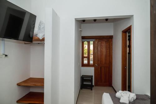um quarto com uma cama, uma televisão e uma porta em HOTEL ALTIPLANO VILLA DE LEYVA em Villa de Leyva