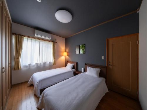 Habitación de hotel con 2 camas y ventana en 1組限定　1棟貸切 「おとまり忠左衛門」　 グループや3世代旅行に最適　　　　 en Ikeda