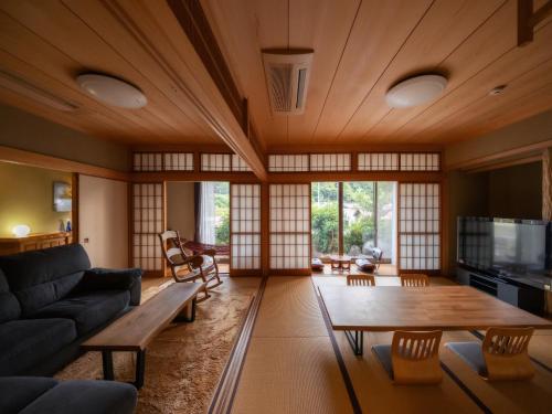 uma sala de estar com um sofá e uma mesa em 1組限定　1棟貸切 「おとまり忠左衛門」　 グループや3世代旅行に最適　　　　 em Ikeda