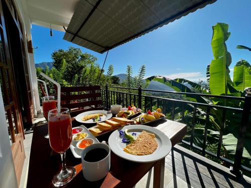 una mesa de desayuno con comida y bebida en el balcón en Eagle View villa en Ella