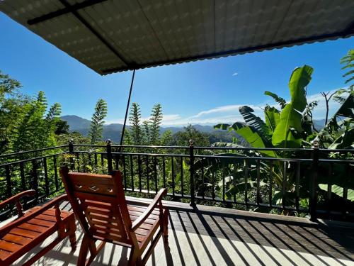 a deck with two wooden benches on a balcony at Eagle View villa in Ella