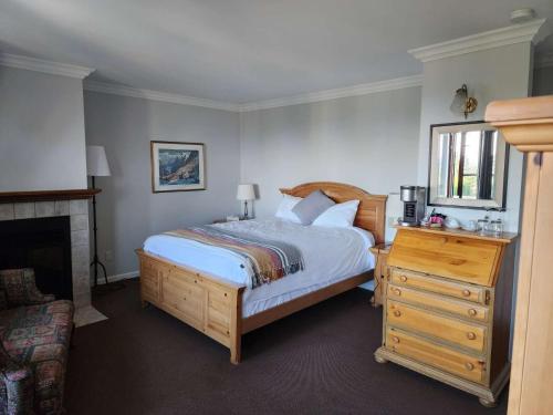 a bedroom with a bed and a dresser with a mirror at Auberge des Nuages in La Malbaie