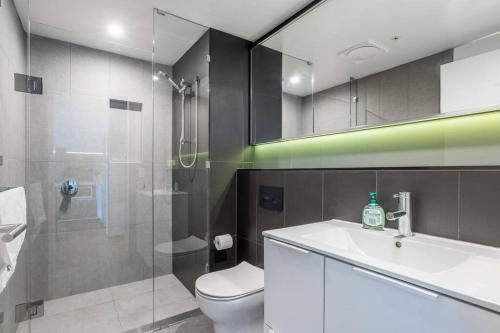 a bathroom with a shower and a toilet and a sink at Vibrant Inner City Living 1 bedroom Apartment in Brisbane