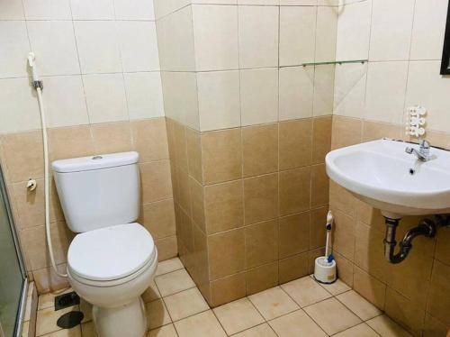 a bathroom with a toilet and a sink at Apartemen Paladian Kelapa Gading Syariah in Jakarta