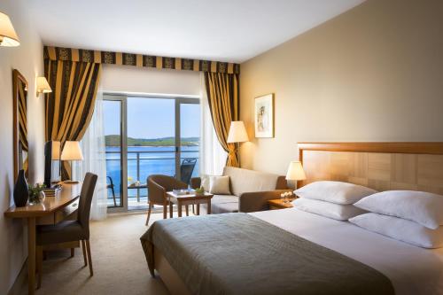 a hotel room with a bed and a view of the water at Aminess Grand Azur Hotel in Orebić