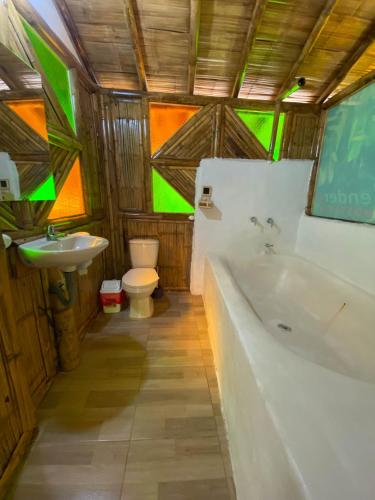 a bathroom with a tub and a toilet and a sink at Hostería El Sendero - Cocorná in Cocorná
