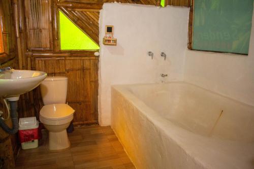 a bathroom with a tub and a toilet and a sink at Hostería El Sendero - Cocorná in Cocorná