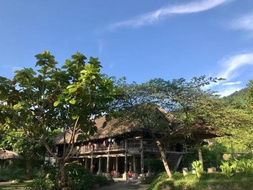 a large house with a thatched roof at Tay Farmhouse in Ha Giang