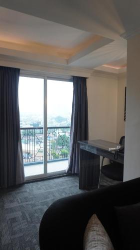 a hotel room with a large window and a desk at MAKATI Isabela Luxury in Manila
