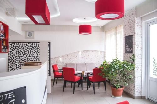 a dining room with red chairs and a table at Garni hotel Alma in Pirot