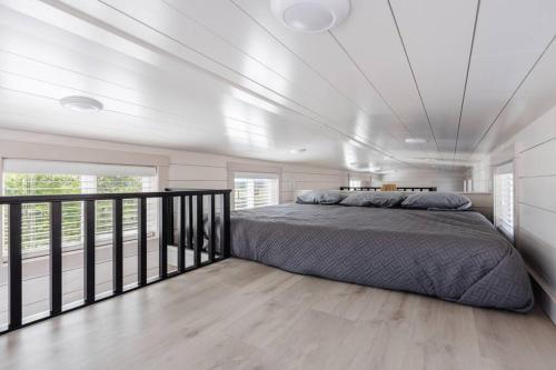 ein Schlafzimmer mit einem Bett und einem Balkon in der Unterkunft Convient tiny home private deck in Apple Valley