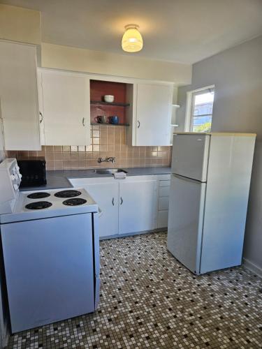 a kitchen with white appliances and a white refrigerator at 2400 Motel in Vancouver