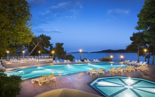 a pool with chaise lounge chairs and a resort at Aminess Grand Azur Hotel in Orebić