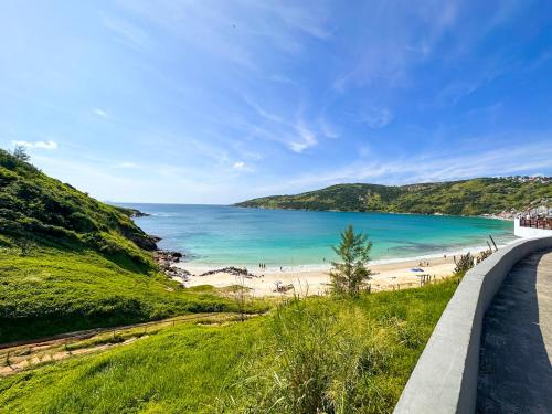 a road next to a beach with the ocean at Luz do Sol Prainha - 3 Quartos in Arraial do Cabo