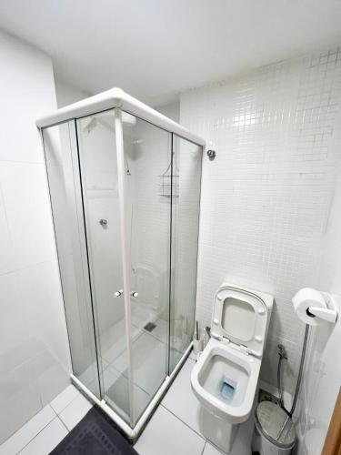 a white bathroom with a shower and a toilet at Luz do Sol Prainha - 3 Quartos in Arraial do Cabo
