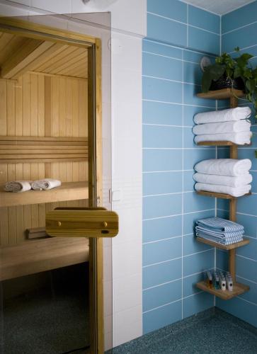 a bathroom with blue walls and a mirror and towels at Hotell Blå Blom in Gustavsberg