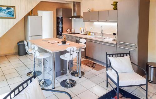 une cuisine avec une table et des chaises dans une cuisine dans l'établissement 1 Bedroom Amazing Home In Plouigneau, à Plouigneau
