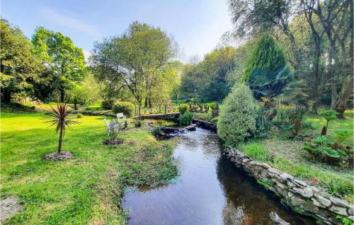 un jardin avec une rivière, des arbres et un pont dans l'établissement 1 Bedroom Amazing Home In Plouigneau, à Plouigneau