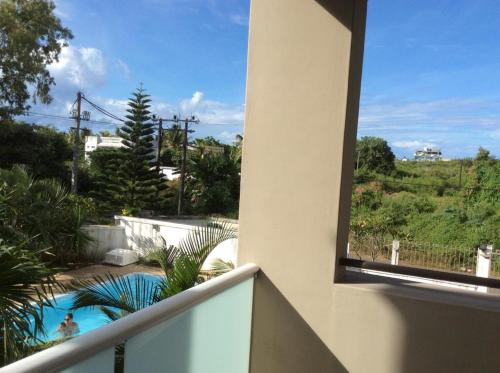 a balcony with a view of a swimming pool at Spacious apartment in Pereybere 115 m² with shared pool in Pereybere