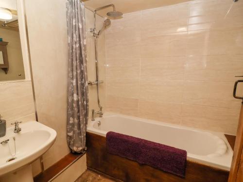 a bathroom with a bath tub and a sink at Moldy Warp Barn in Keighley