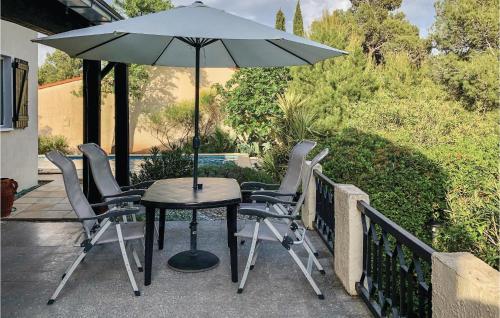 d'une table et de chaises sous un parasol sur le balcon. dans l'établissement Awesome Home In Pouzols-Minervois, à Pouzols-Minervois